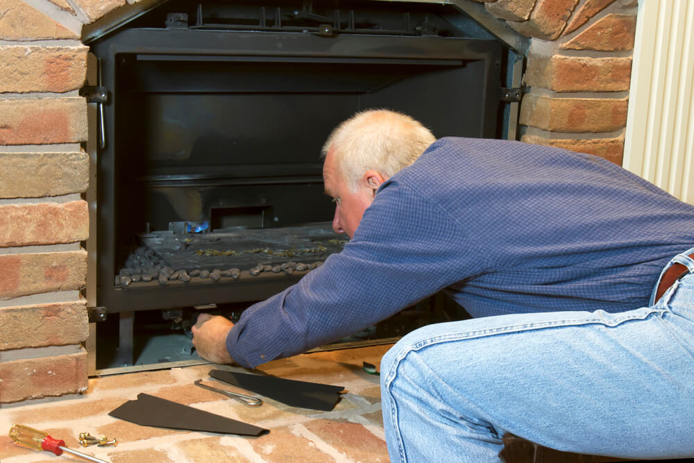 man working on gas fireplace